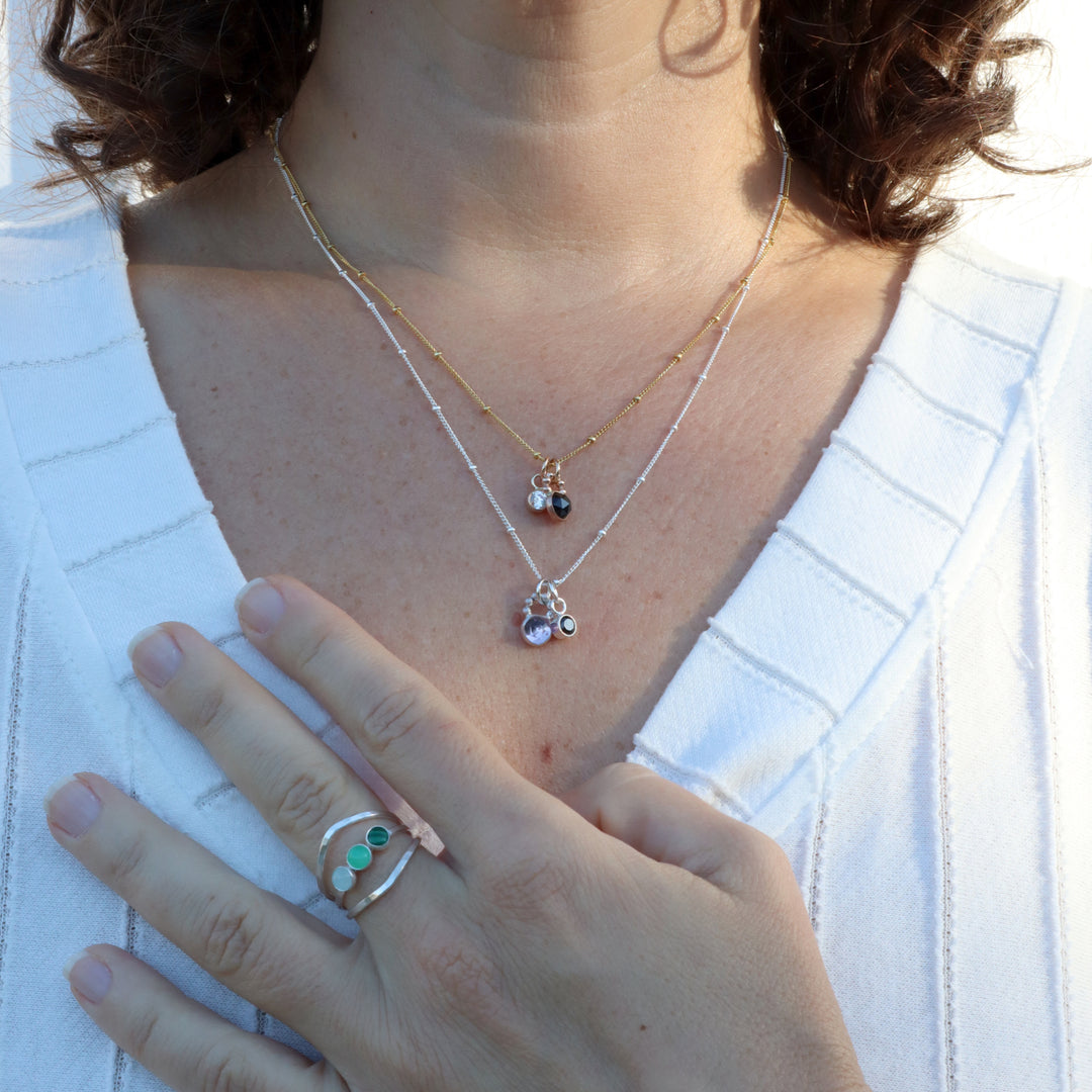 model wearing one of a kind charm necklaces and rings