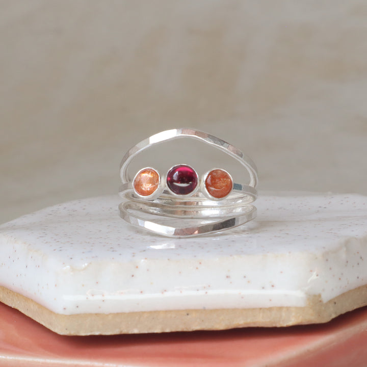 sterling silver one of a kind ring with sunstone and garnet gemstones on a hammered triple band
