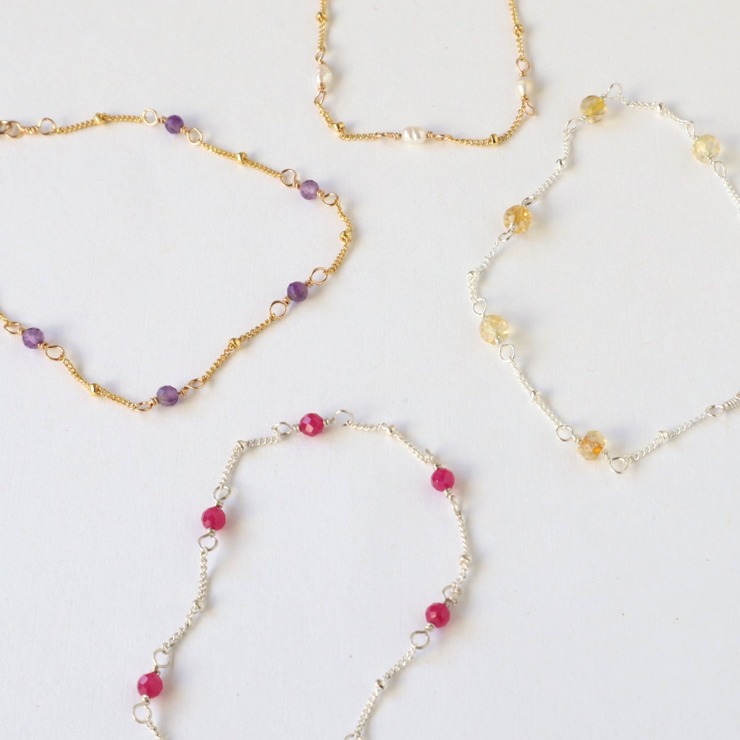 birthstone bracelets in sterling silver and 14k gold filled with amethyst, pearl, citrine and ruby gemstones