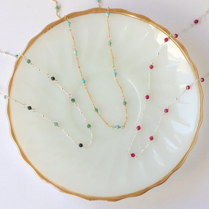 birthstone necklaces in sterling silver and 14k gold filled, showing emerald, turquoise and ruby gemstones