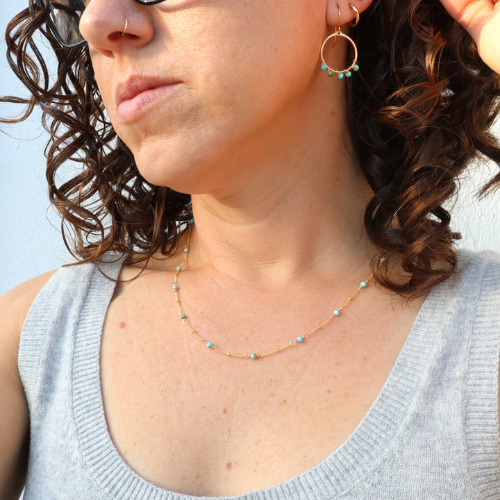 model wearing birthstone necklace and birthstone earrings with turquoise gemstones