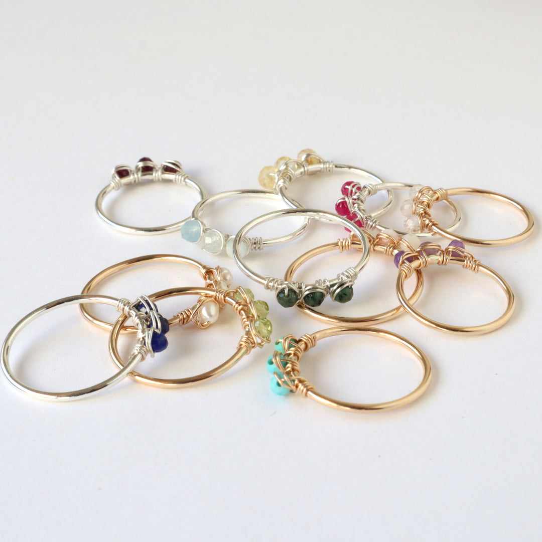 pile of birthstone rings in sterling silver or 14k gold filled