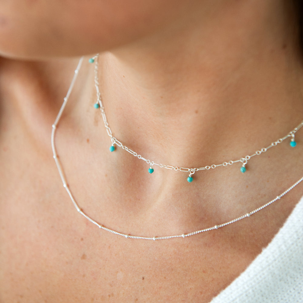 twinkle chain necklace and dewdrop choker necklace layered necklace set in turquoise in sterling silver on model