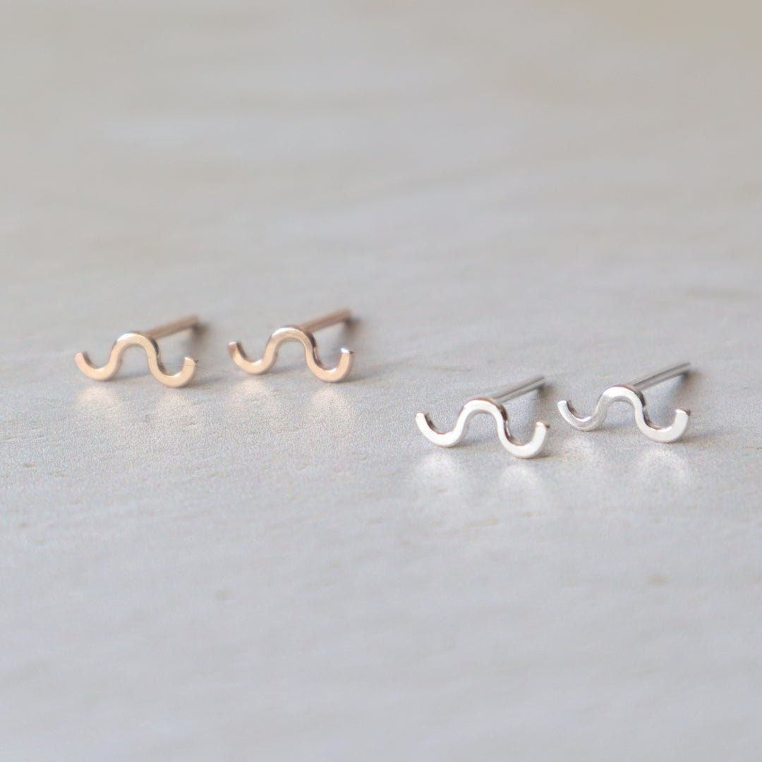 Pair of wavy line earrings on a light gray background