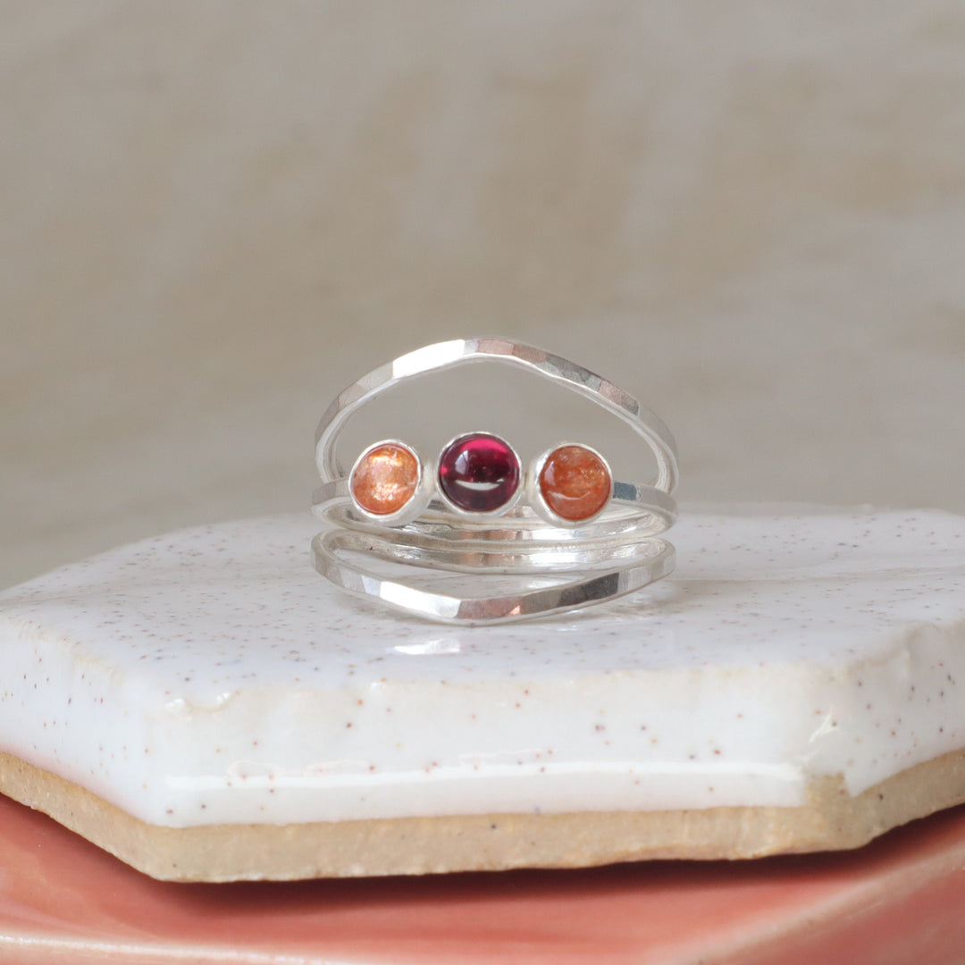 sterling silver one of a kind ring with sunstone and garnet gemstones on a hammered triple band